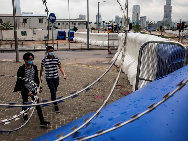 People walk past extra barricades that have been erected in Hong Kong. Picture: AFP