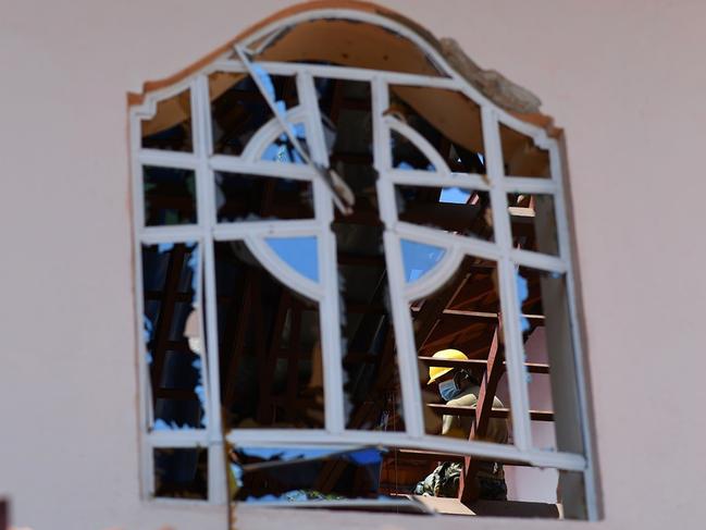 A worker clears debris from the roof of St Sebastian's Church in Negombo, a day after it was hit in a series of bomb blasts. Picture: AFP