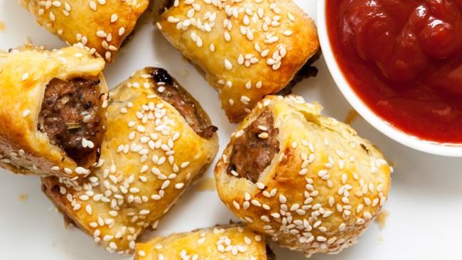 Homemade sausage rolls with sesame seeds and tomato sauce.