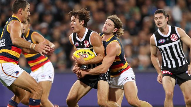 ADELAIDE, AUSTRALIA - APRIL 01: Connor Rozee of the Power is tackled by Sam Berry of the Crows during the 2023 AFL Round 03 match between the Port Adelaide Power and the Adelaide Crows at Adelaide Oval on April 1, 2023 in Adelaide, Australia. (Photo by Sarah Reed/AFL Photos via Getty Images)