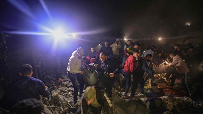 People carry an injured person as civilians look for survivors in the rubble of destroyed buildings following Israeli bombardment on Rafah in the southern Gaza Strip. Picture: AFP