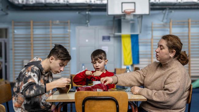 Ukrainians Svetlana (R) and her children Svyatoslav (L) and Ivan (C), are seen in temporary accommodation in a sports hall in Przemysl, in eastern Poland. Picture: AFP