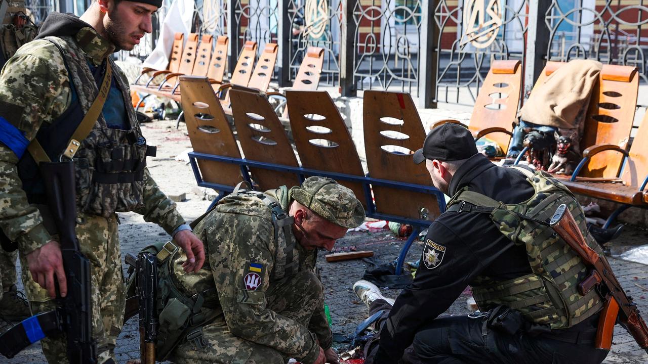 Ukrainian service men check for signs of life among casualties. Picture: Anatolii Stepanov/AFP