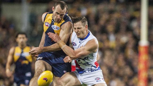 Shannon Hurn gets a kick away under pressure from Clay Smith.