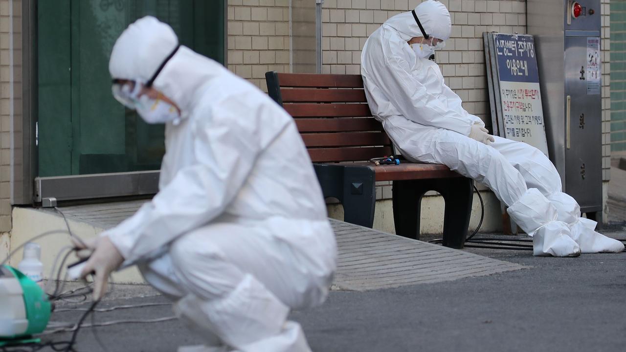 A medical worker wearing protective gear takes a rest as he waits for ambulances carrying patients infected with the COVID-19 coronavirus at an entrance of a hospital in Daegu. Picture: Yonhap/AFP