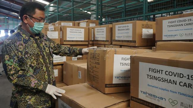 An Indonesian official inspects boxes of medical equipment at Jakarta's international airport. Picture: Farjin Raharo/AFP