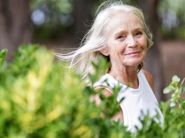 Senior woman walking in the park, background with copy space, full frame horizontal composition. Retiree, retirement generic