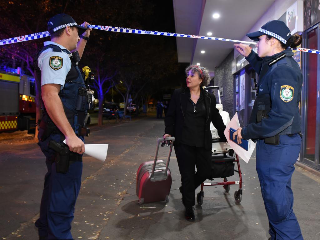 Officers let a resident through a police cordon as Mascot Towers is evacuated. Picture: Flavio Brancaleone