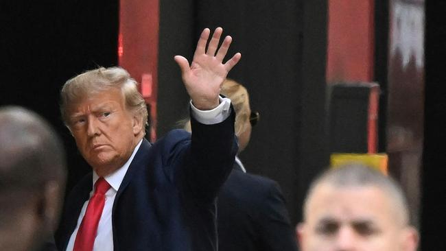 Former US president Donald Trump waves as he arrives at Trump Tower in New York.