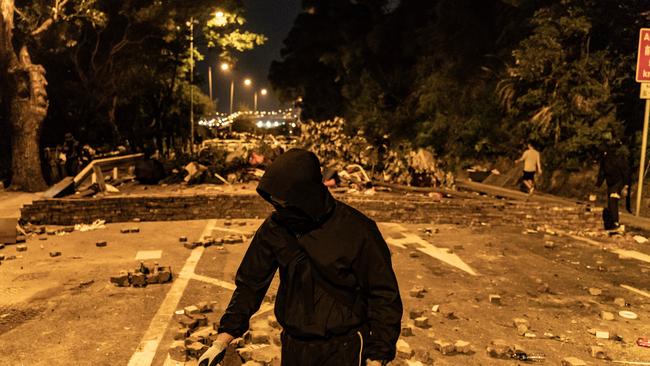 A pro-democracy protester walks in front of a makeshift brick wall on a street during a demonstration at the Chinese University of Hong Kong. Picture: Anthony Kwan/Getty