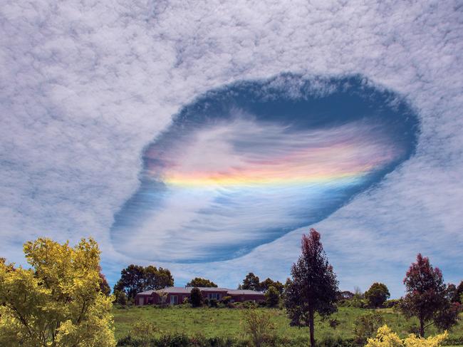 MUST MENTION 2016 Australian Weather Calendar MUST CREDIT PHOTOGRAPHER July - Fallstreak hole over Korumburra, Vic (David Barton) David Barton and his wife spotted a rare phenomenon over eastern Victoria on 3 November 2014. Fallstreak holes, or hole punch clouds, form in clouds that contain supercooled water droplets—at a temperature below freezing point, but not frozen. A trigger such as a passing aircraft causes ice crystals to form, and a chain reaction makes water droplets around those crystals evaporate, leaving a ‘hole’ around the wispy patch of ice crystals. Sunlight passing through this thin part of the cloud is refracted, or bent, with different wavelengths (i.e. colours) spreading out in a similar way to how rainbows form. This is called cloud iridescence or irisation. David took this shot from his front porch, with a Nikon D7100 and an 18–140mm lens.