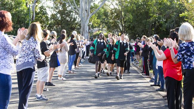 Bray Park State High School staff welcome back their year 12 students with a socially distanced guard of honour after COVID-19 restrictions are eased. Agyo Major, Tayla Pascoe and Kynan Elford lead the group into school. Picture: Renae Droop/RDW Photography