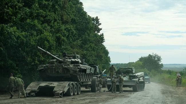 Ukrainian soldiers load an abandoned Russian military vehicle on a trailer during the Ukrainian army counteroffensive in Kharkiv region. Picture: AFP