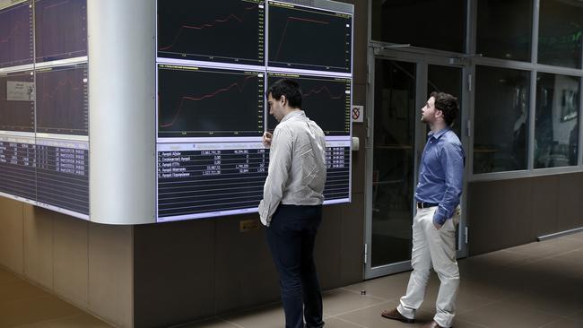 Two men check an index board in the reception hall of the Athens' Stock Exchange, which has suffered three straight days of losses after reopening amid capital controls.