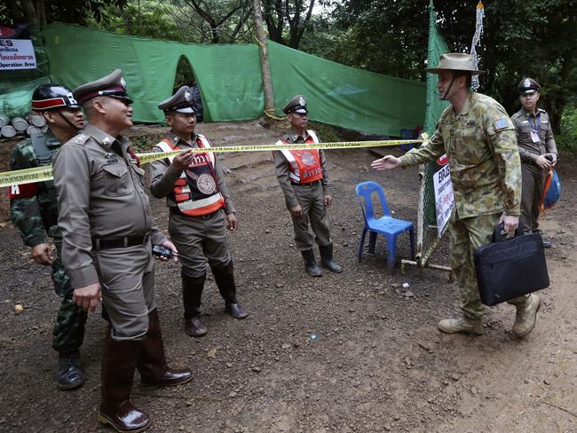 Australian Federal Police and Defence Force personnel arrive near the cave. Picture: AP