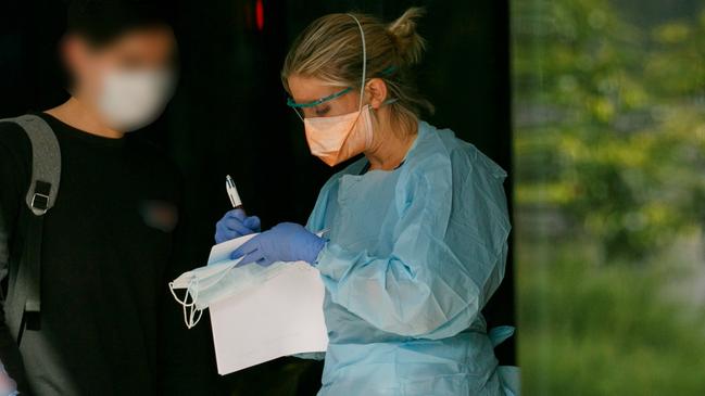 Patient in mask been seen by triage nurse at Northern Beaches Hospital's new COVID-19 clinic. Picture: Tim Pascoe