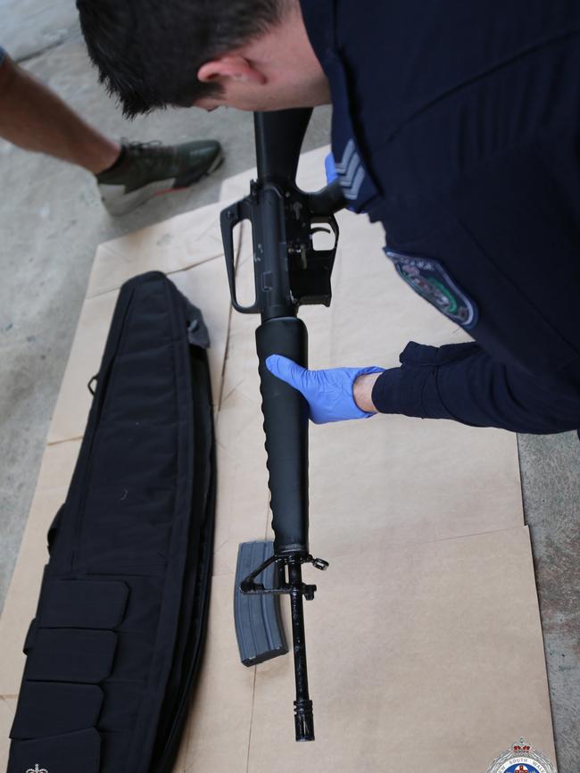 An officer examines evidence from the searches carried out on Wednesday. Picture: NSW Police/AFP