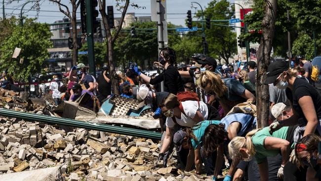 People work to clean up outside a burned building in Minneapolis.