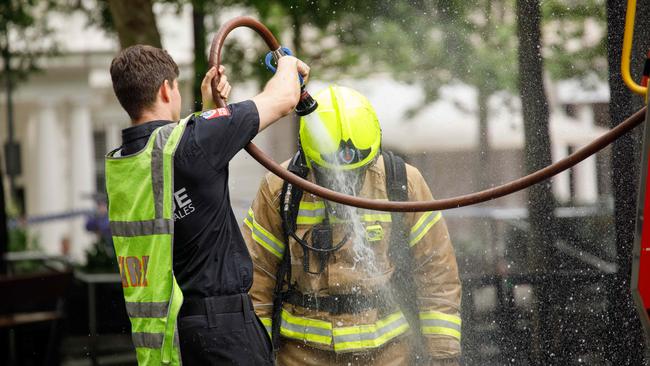 A fireman being doused in water after attending to the blaze. Picture: NCA NewsWire / Max Mason-Hubers