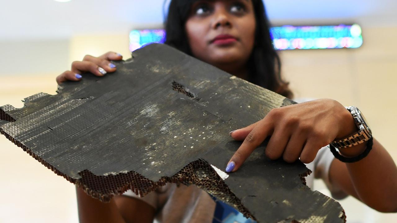 Grace Subathirai Nathan, daughter of Malaysian Airlines flight MH370 passenger Anne Daisy, shows a piece of debris believed to be from flight MH370. Picture: Mohd Rasfan/AFP