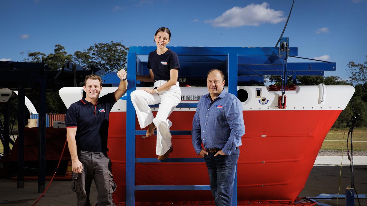 Helitak production manager Harry Bailey, business manager Emily Schellaars, and CEO Jason Schellaars with the Firetank FT4500 UH60 self filling water tank for firefighting helicopters. Picture: Lachie Millard