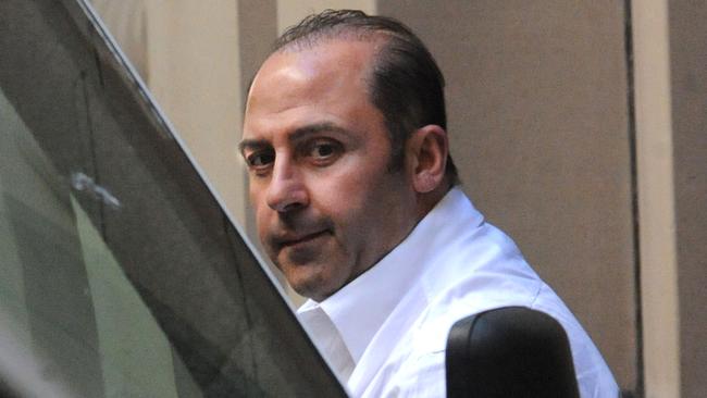 Underworld figure Tony Mokbel is lead into a prison van at the Supreme Court in Melbourne, Tuesday, Oct 18, 2011. Mokbel has applied to change his plea on drugs charges from guilty to not guilty. (AAP Image/Julian Smith) NO ARCHIVING