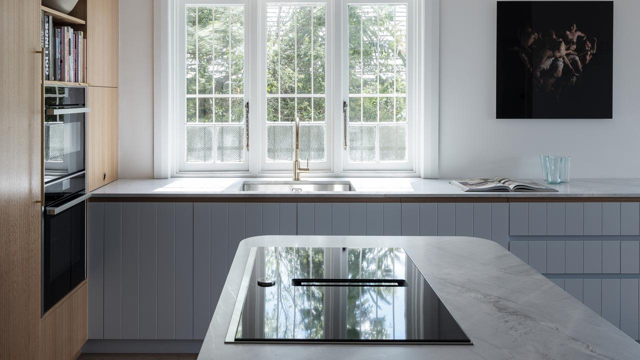 The old U-shape kitchen was replaced with an open plan island bench to make it easier to cook and entertain in the space.