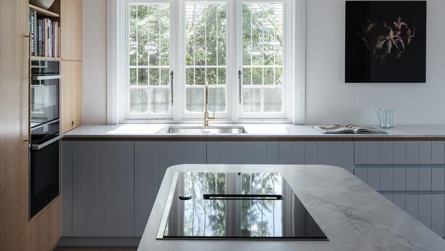 The old U-shape kitchen was replaced with an open plan island bench to make it easier to cook and entertain in the space.