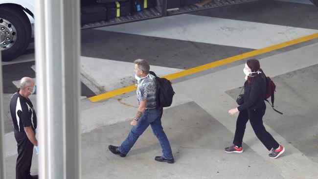 Police and Army personnel watch as Passengers arriving into Brisbane International Airport and forced into quarantine. Passengers getting off and being taken to buses before taken to hotels to quarantine, Sunday 29th March 2020 – Photo Steve Pohlner