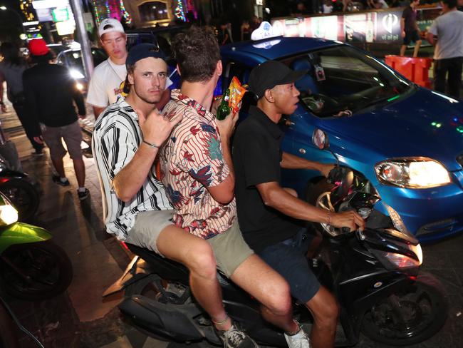 It's often that two are seated behind the driver as they drive down the main strip of Jalan Legian in Kuta. Picture: Liam Kidston