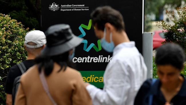 People wait in a queue to receive benefit payouts at a Centerlink payment centre. Picture: AFP