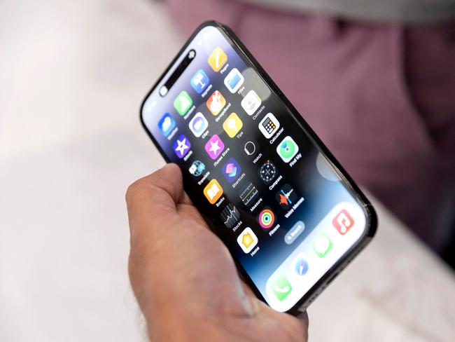 An Apple associate holds one of the new iPhone Pros during a launch event for new products at Apple headquarters in Cupertino, California, on September 7, 2022. - Apple unveiled several new products including a new iPhone 14 and 14 Pro, three Apple watches, and new AirPod Pros during the event. (Photo by Brittany Hosea-Small / AFP)