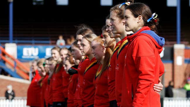 Sally Riley, Coach of Ballarat Clarendon College lines up with their players for the national anthem. Picture: Dylan Burns/AFL Photos via Getty Images