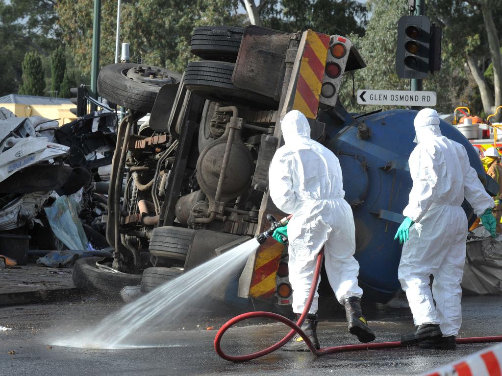 Hazmat crews hose down Glen Osmond Rd after a septic-waste truck crashed into stationary cars. Picture: Roger Wyman