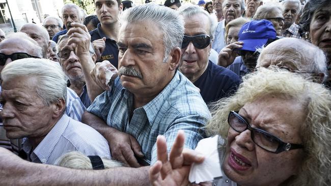 ATHENS, GREECE - JULY 1: Pensioners line up outside a National Bank branch on July 1, 2015 in Athens, Greece. Bank branches around Greece are opened on Wednesday to allow pensioners to receive a small part of their benefits. Greece's last-minute overtures to international creditors for financial aid on Tuesday were not enough to save the country from becoming the first developed economy to default on a loan with the International Monetary Fund. (Photo by Milos Bicanski/Getty Images)