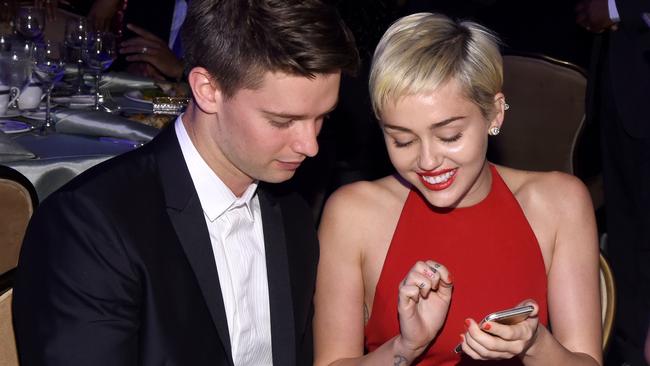 Earlier: The happy couple check texts the night before the Grammys at a pre-party.