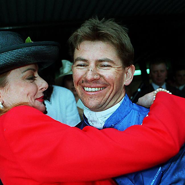 Jockey Wayne Harris is hugged by his wife Linda after winning the Melbourne Cup.