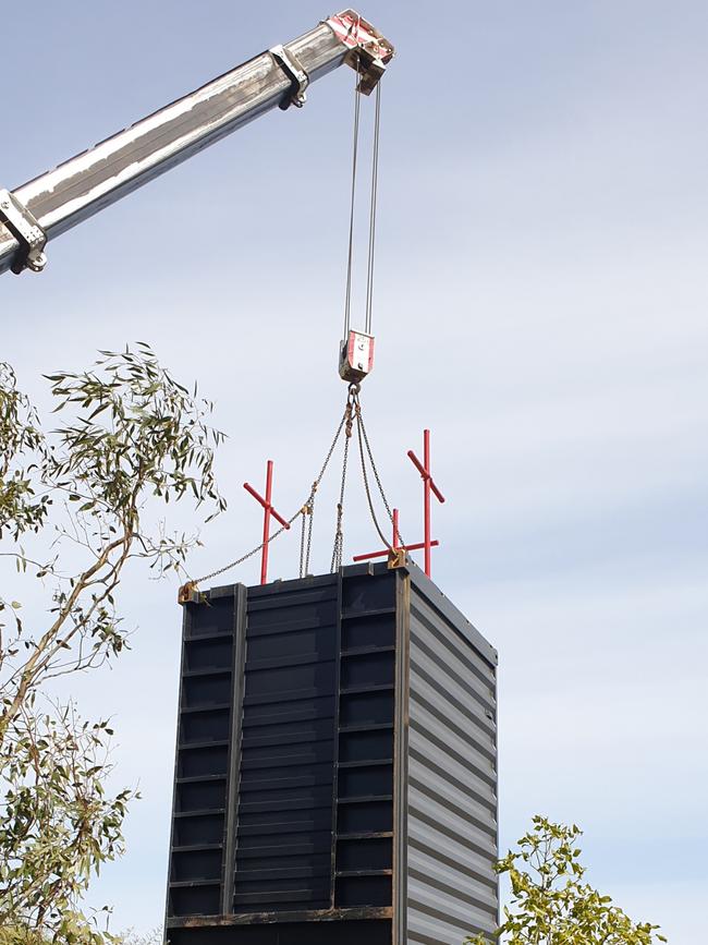 A crane placing the shipping container at the centre of the dispute between businessman Lance Vater and Burnside Council at Auldana. Picture: Colin James