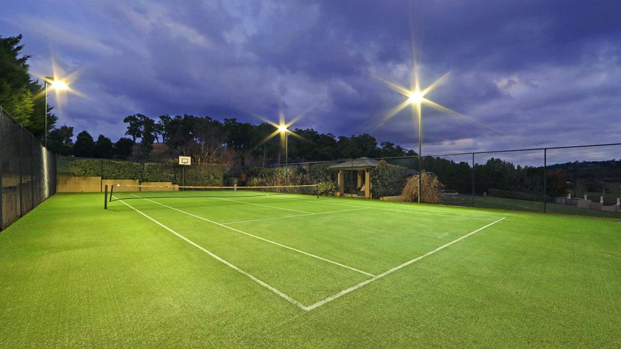 A flood-lit tennis court comes with a basketball ring to suit active families.