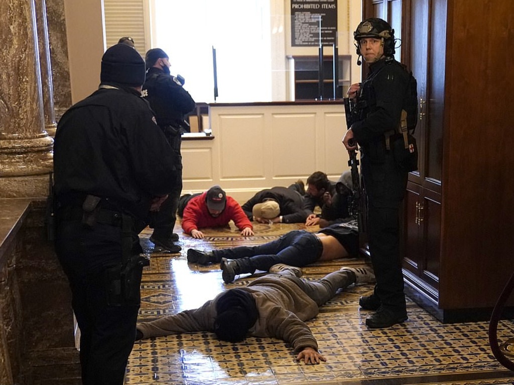 Capitol Police detain a group of protesters outside of the House Chamber during a joint session of Congress. Picture: Getty Images