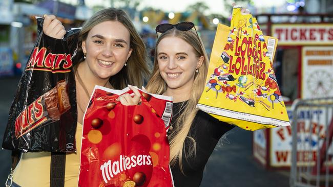 Brisbane visitors Kimmy Balmer (left) and Allana Acton with show bags at the Toowoomba Royal Show, Thursday, March 30, 2023. Picture: Kevin Farmer