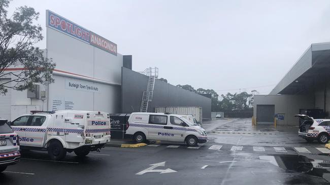 Police vehicles surrounding the charity bin where the woman’s body was found. Picture: Glenn Hampson