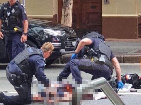 Senior Constable Dustin Osborne (right, wearing blue gloves), uses his tactical first aid training in an attempt to save the life of a man who was shot by police on Mary Street in the Brisbane CBD in February. The man had allegedly stabbed another man in the city before being shot. He later died. Picture: Supplied