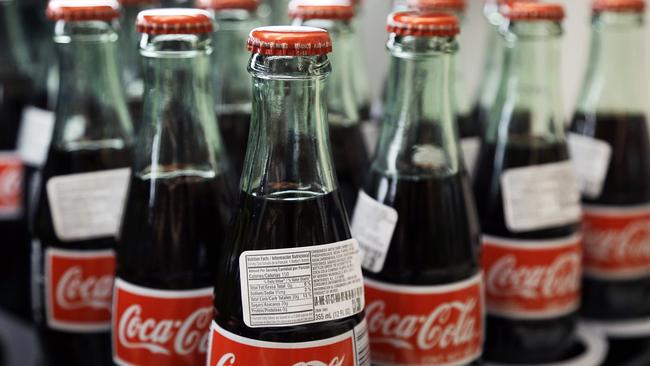 In this July 9, 2015 photo, bottles of Coca-Cola are on display at a Haverhill, Mass. supermarket. Coca-Cola reports quarterly financial results on Wednesday, July 22, 2015.(AP Photo/Elise Amendola)