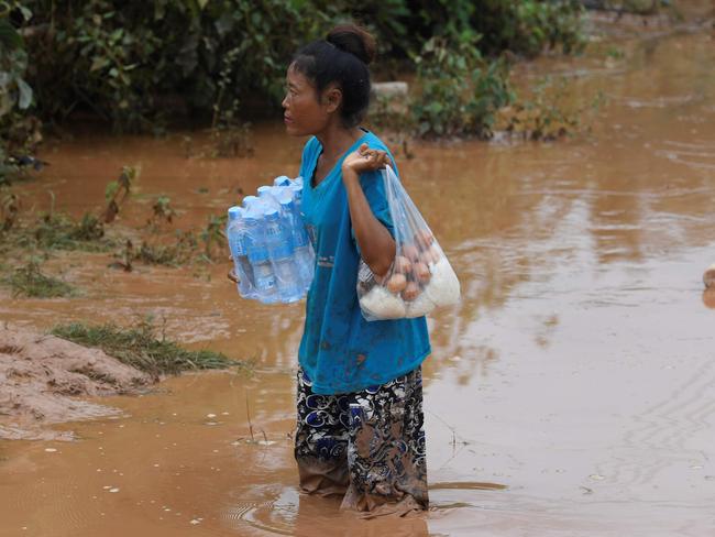 A flood victim receives food aid from Laotian relief personnel in Sanamxai, Attapeu province. Picture: AFP