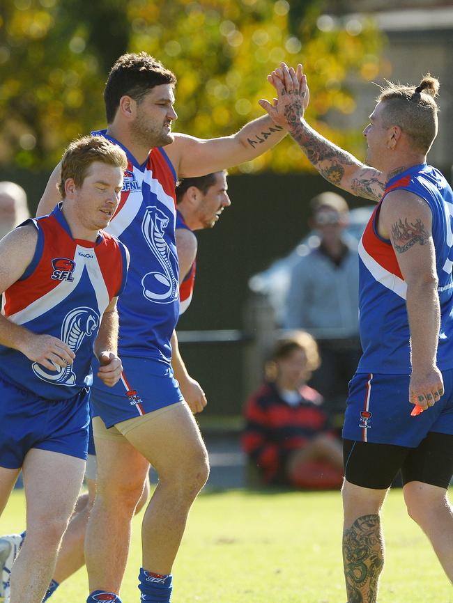 Brendan Fevola has a high-five for Sandown teammate Jamie Proctor.