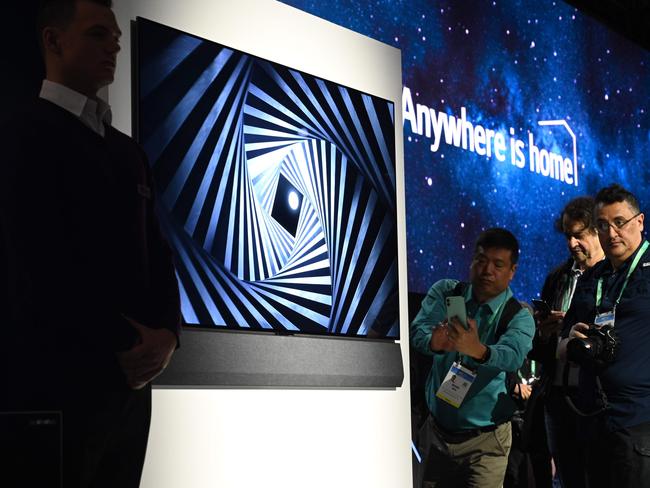 Attendees view the super thin LG GX series OLED 8K television at the 2020 Consumer Electronics Show. Picture: AFP