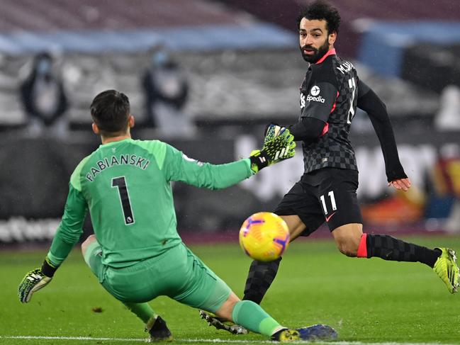 LONDON, ENGLAND - JANUARY 31: Mohamed Salah of Liverpool scores their side's second goal past Lukasz Fabianski of West Ham United during the Premier League match between West Ham United and Liverpool at London Stadium on January 31, 2021 in London, England. Sporting stadiums around the UK remain under strict restrictions due to the Coronavirus Pandemic as Government social distancing laws prohibit fans inside venues resulting in games being played behind closed doors. (Photo by Justin Setterfield/Getty Images)