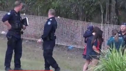 Officers and family reuniting after the girls were brought out of the drain. Photo: 9 News Gold Coast