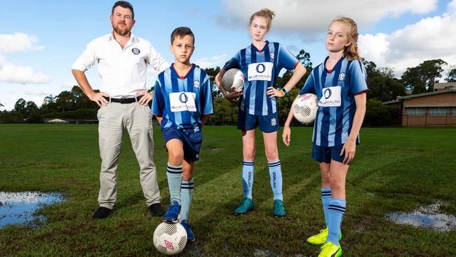 Roselea FC VP of women’s football Rohan Primrose, Adam Ilic, 10, Alessandra Primrose, 14, and Isabella Primrose, 11, at the soggy fields in Carlingford. Picture: Jordan Shields